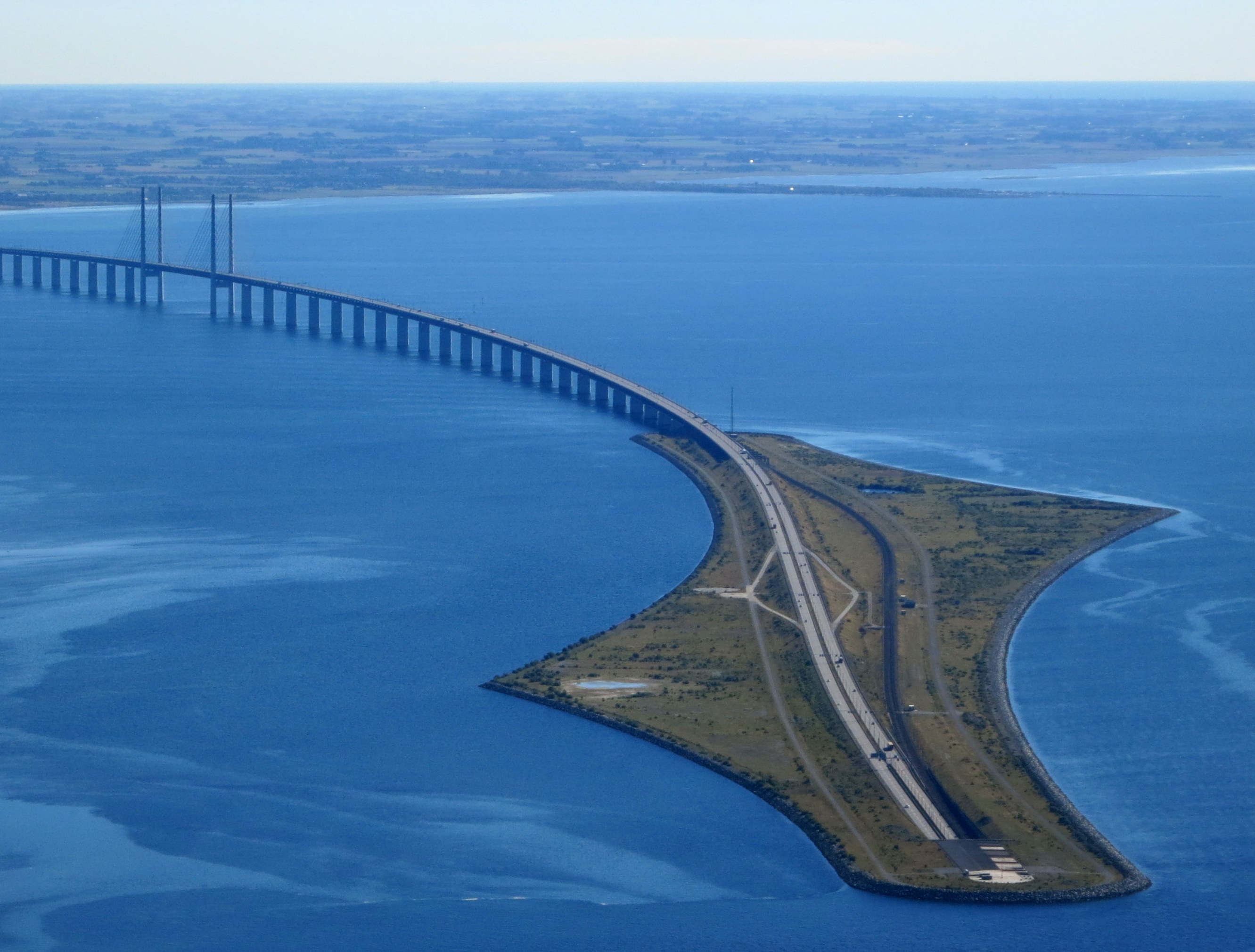 Aerial view of the Øresund Bridge sweeping onto Peberholm, where the road enters the underwater tunnel